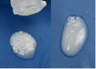 Shows examples of drops of the medication, some with a few balls suspended within the white liquid and some with many